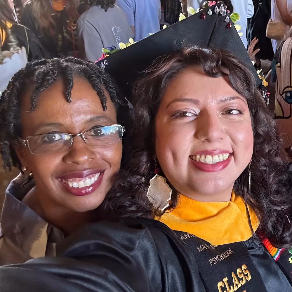 Audrey Gamble smiling with a student at a graduation celebration.