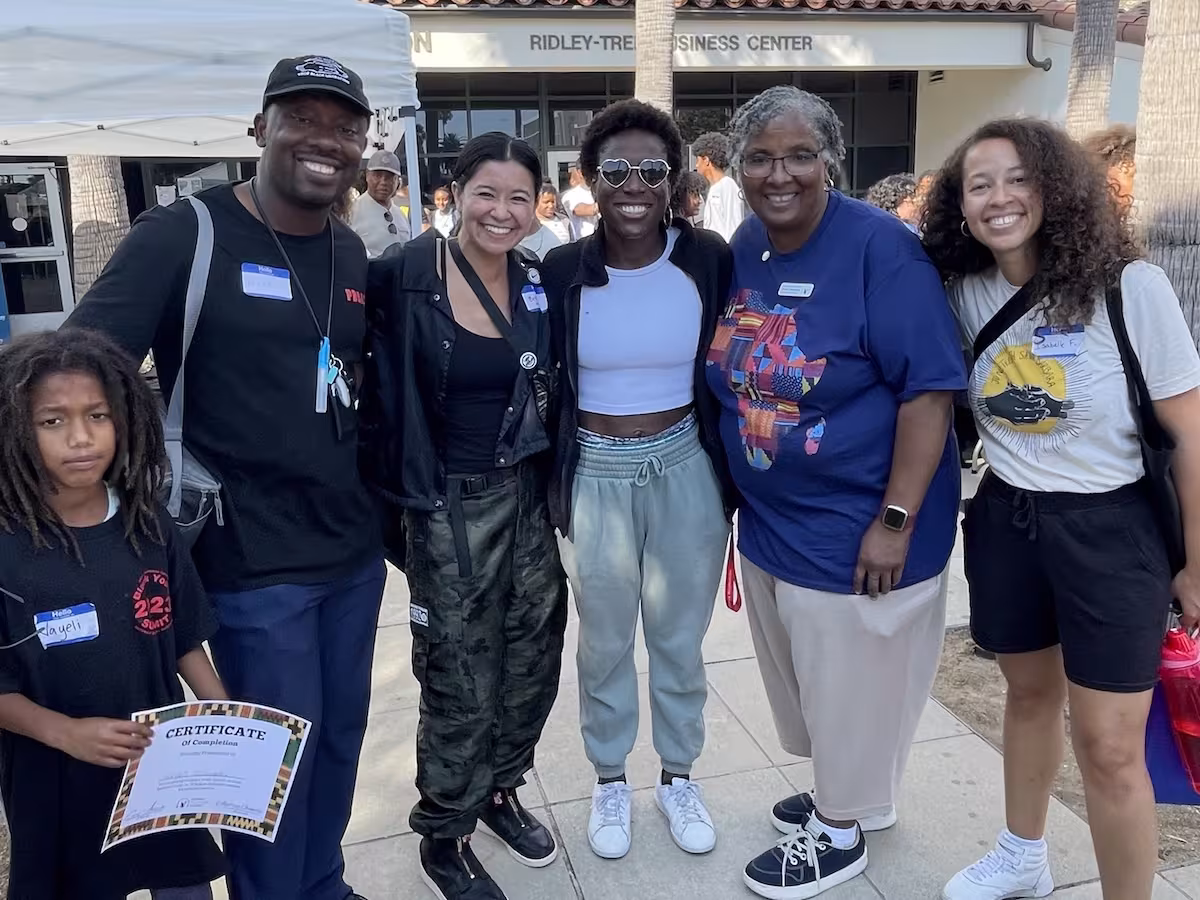 Students and community leaders standing together outdoors during a youth arts and culture event.
