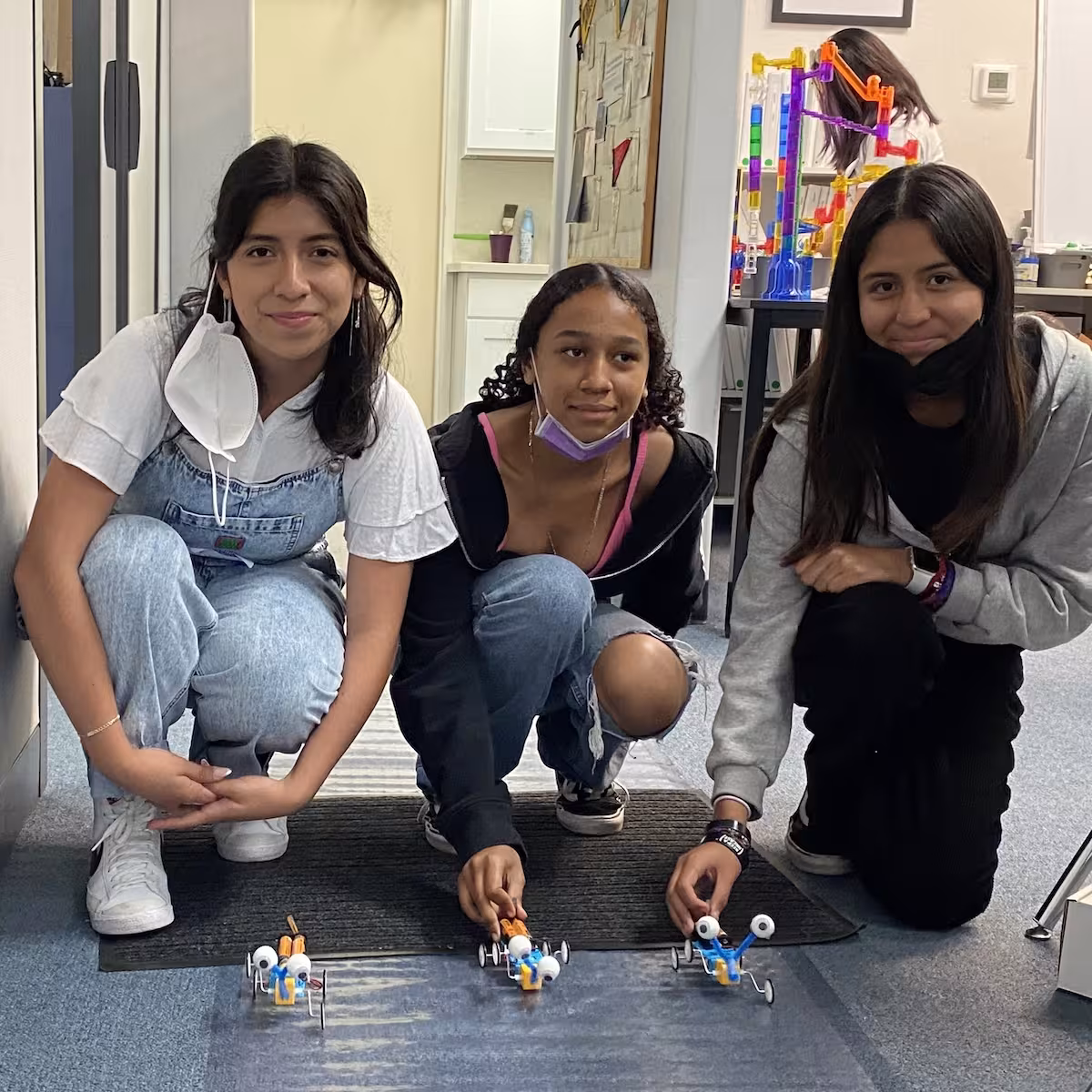 Crystal working with students during a hands-on STEAM activity.