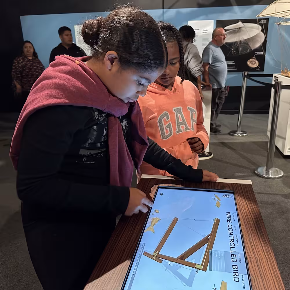 Students interacting with an exhibit during a museum learning activity.