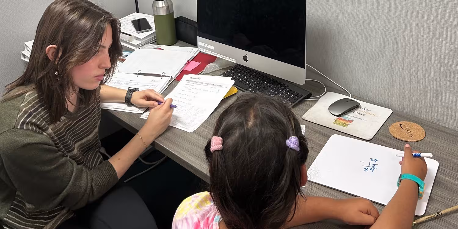An instructor working with a student during a learning assessment.
